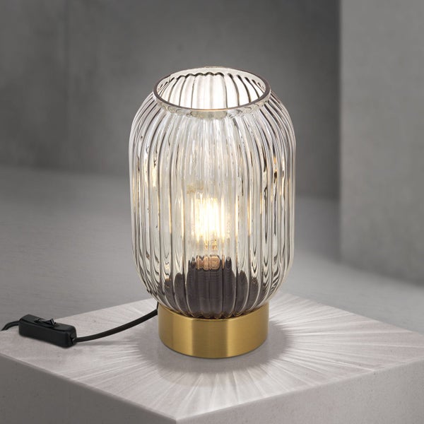 Dekorative Tischleuchte mit Lampenschirm aus Glas und einem Metallsockel.