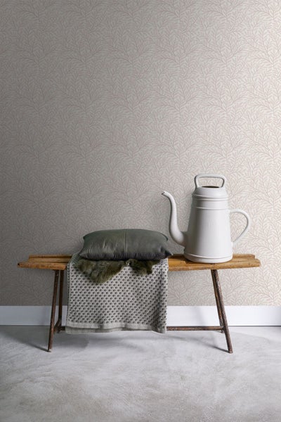Szene mit einer Tapete mit Blätterdesign, einer Bank, einem Kissen und einer Gießkanne.