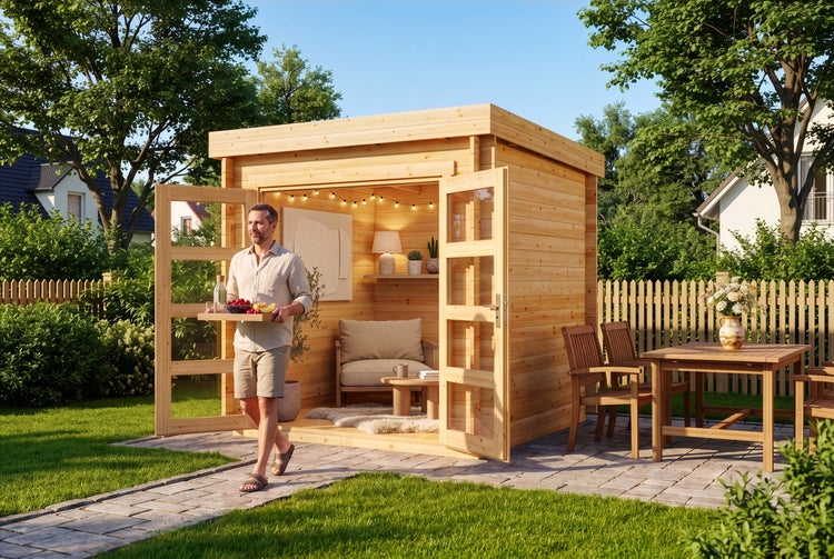 Modernes Gartenhaus aus Holz mit Flachdach und Glastüren, eingerichtet als gemütlicher Rückzugsort im grünen Garten mit Terrasse und Sitzgruppe.