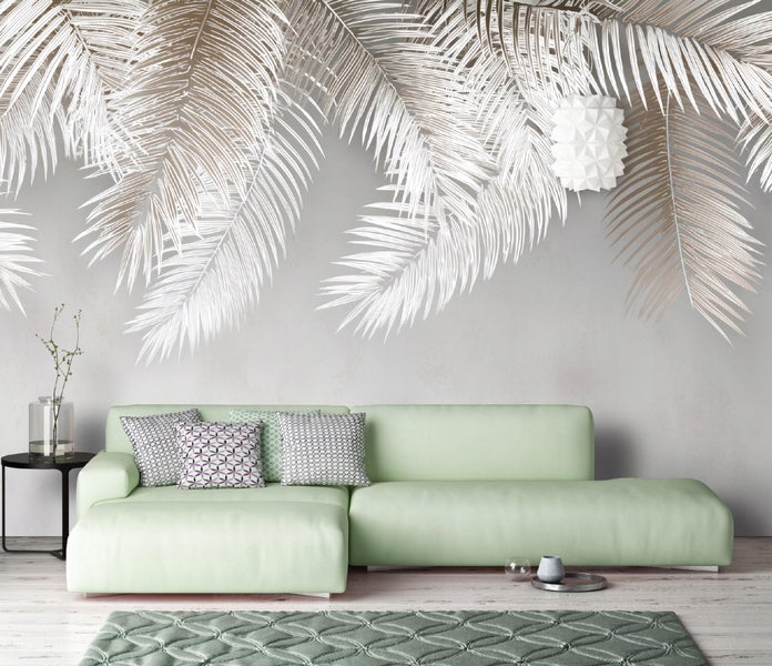 Wohnzimmer mit grüner Couch, Teppich und Wanddeko mit Palmenmotiven