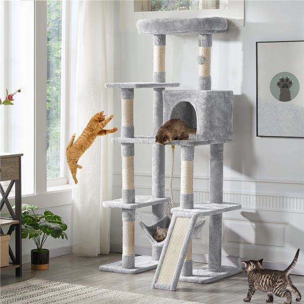 Mehrstöckiger, grauer Katzenkratzbaum mit Plattformen, Höhle, Hängematte und Sisalstämmen in einem hellen Raum mit drei Katzen.