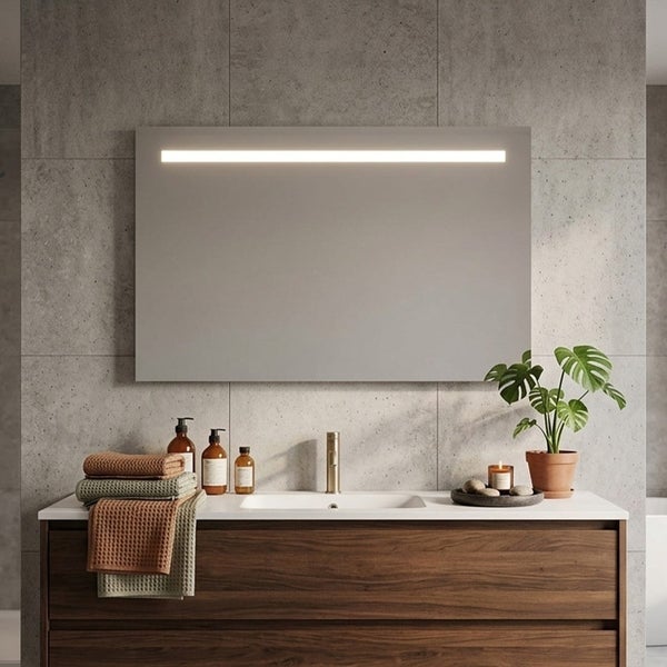 Rechteckiger Badezimmerspiegel mit LED-Lichtleiste über einem Waschtisch aus Holz vor einer Wand aus grauen Steinfliesen.