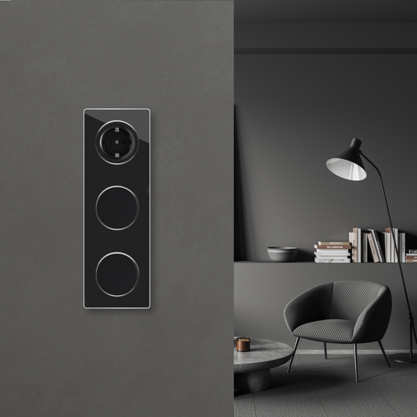 Moderne Steckdose und Lichtschalter Kombination in einem Wandelement vor einem minimalistisch eingerichteten Wohnzimmer mit Sessel und Stehlampe.