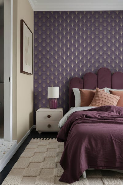 Schlafzimmer mit Bett, Nachttisch, Lampe und gemusterter Tapete für eine gemütliche Atmosphäre