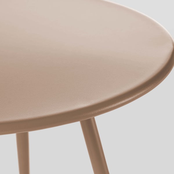 Detail eines runden Metalltisches in Taupe mit matter Oberfläche und schmalen Beinen.