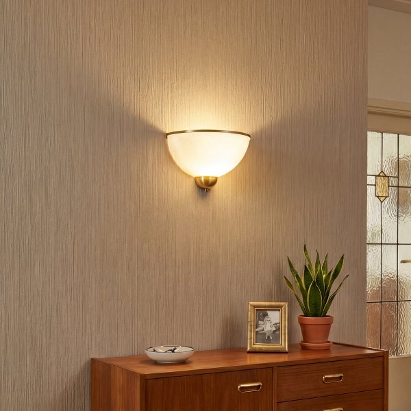 Moderne halbrunde Wandleuchte mit warmem Licht montiert an einer strukturierten Wand über einem Holzkommodenmöbel.