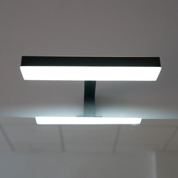 Rechteckige LED-Spiegelleuchte in Schwarz mit weißem Diffusor, montiert über einem Spiegel.