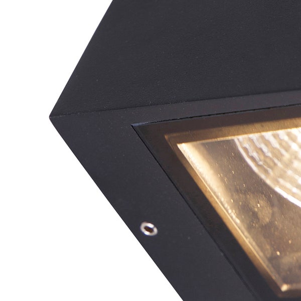 Detailaufnahme einer schwarzen Außenwandleuchte mit matter Oberfläche und Glasabdeckung über dem Leuchtmittel.