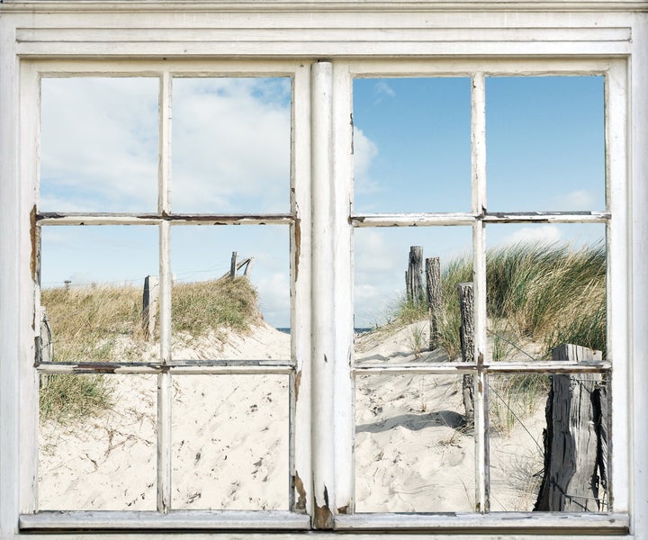 Altes Fenster mit Blick auf einen Sandstrand