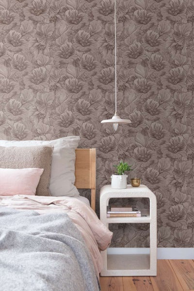 Wohnzimmer mit florale Tapete im Hintergrund, Sideboard aus Holz, gepolsterter Sessel und dekorativem Wandbild vor einem hellen Fenster.