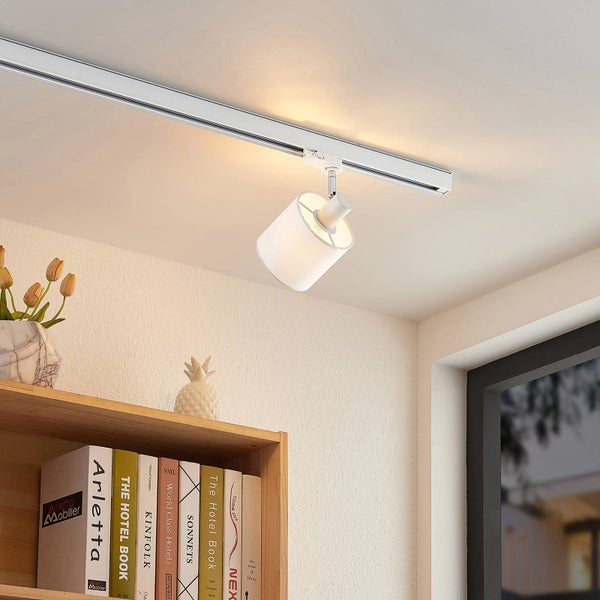 Weißes Schienensystem mit einem Spot aus Stoff an der Decke über einem Bücherregal montiert.