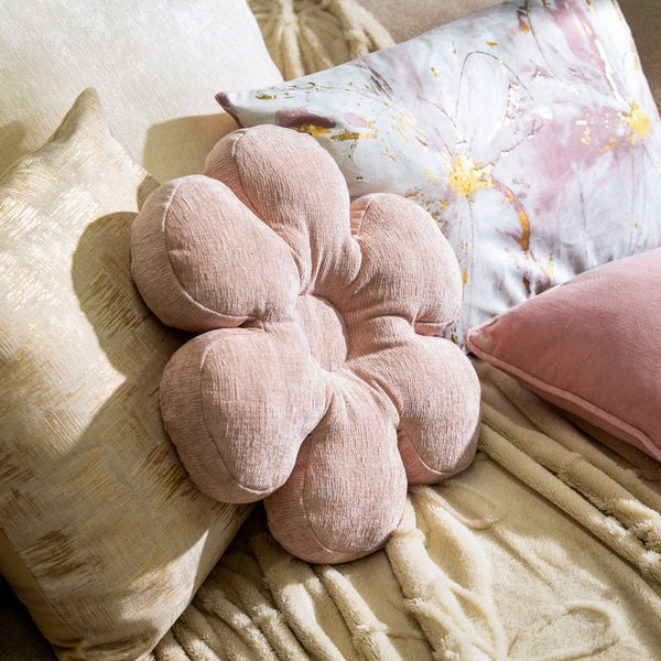 Dekorative Kissenanordnung mit Blumenkissen und Zierkissen auf einer Decke