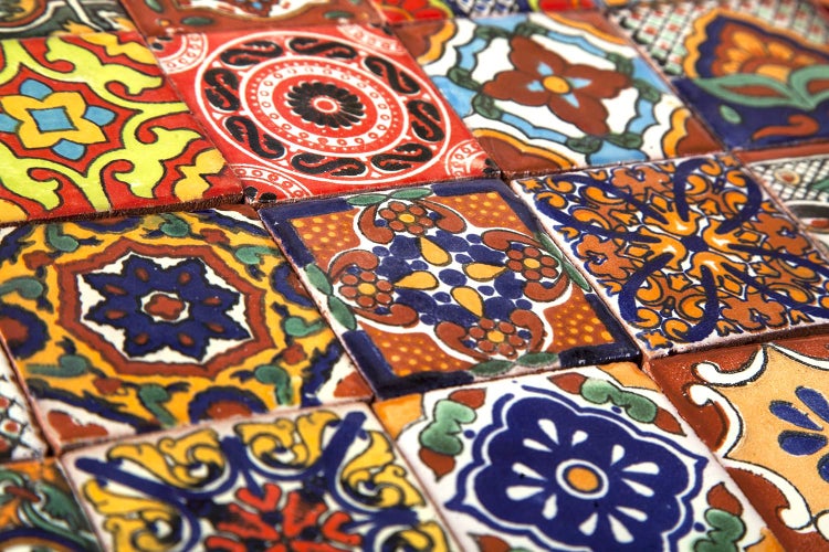 Nahaufnahme von verzierten Keramikfliesen mit floralen und geometrischen Mustern.