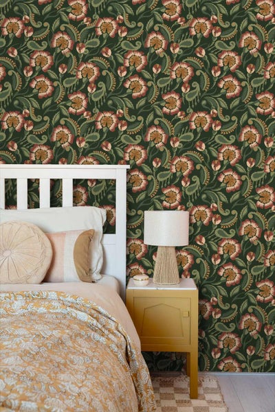 Schlafzimmer mit dunkler floraler Tapete im Vintage-Stil, weißem Holzbett, senfgelbem Nachtschrank und einer Tischleuchte mit Textur.
