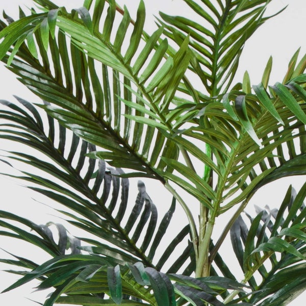 Detailansicht einer künstlichen Palme mit naturgetreuen Palmwedeln für die Innendekoration.