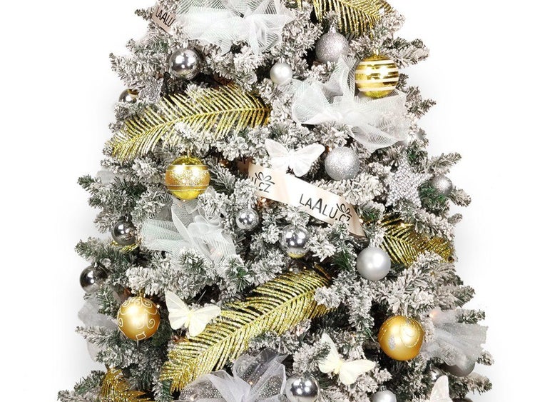 Künstlicher Weihnachtsbaum mit Schneeoptik, dekoriert mit Kugeln, Schleifen, künstlichen Farnen und Schmetterlingen als festliche Dekoration.