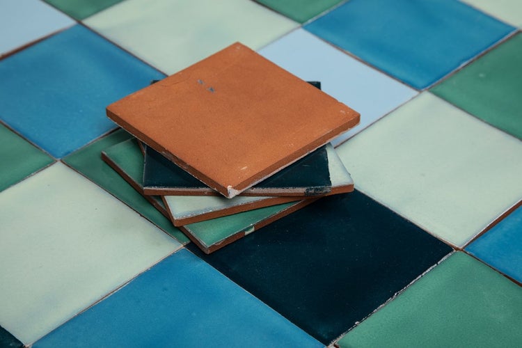 Quadratische Bodenfliesen aus Keramik gestapelt auf verlegtem Fliesenboden