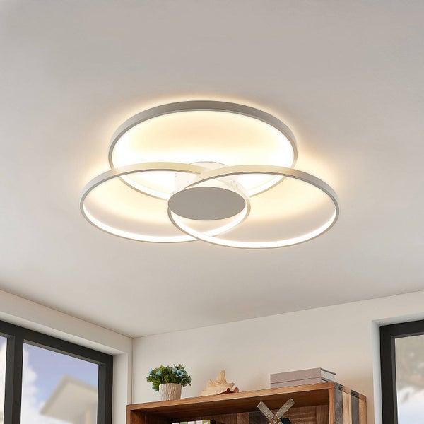 Moderne LED-Deckenleuchte mit drei ineinandergreifenden Ringen in einem hellen Wohnraum.