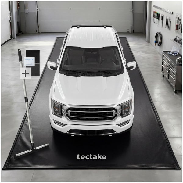 Schwarze tectake Garagenbodenmatte unter einem weißen Pickup mit einem Bodenabzieher und Zubehör in einer hellen, organisierten Werkstatt.