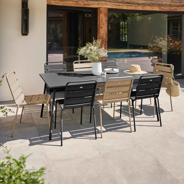 Modernes Gartenmöbel-Set bestehend aus einem großen Esstisch und Metallstühlen in Anthrazit und Beige auf einer Steinterrasse am Pool.