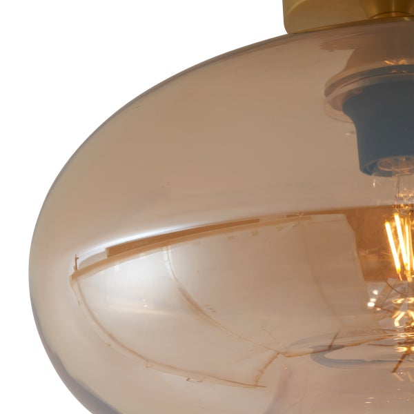 Nahaufnahme einer Pendelleuchte mit transparentem Glasschirm und Glühbirne