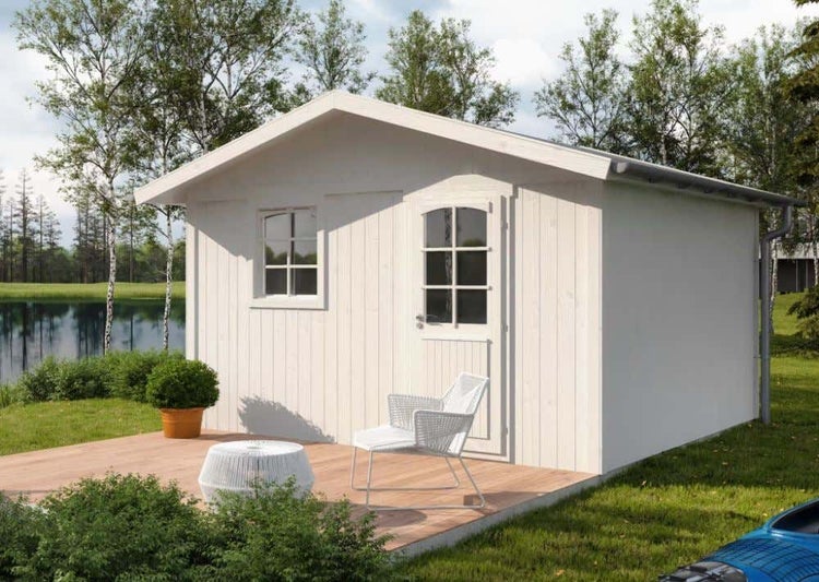 Weißes Gartenhaus aus Holz mit Satteldach, Fenster und Tür auf einer Holzterrasse im Grünen an einem See.
