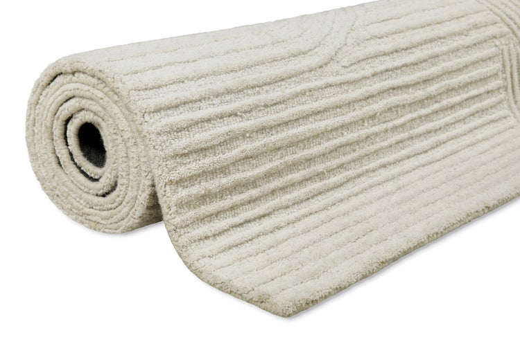Gerollter Teppich mit Rippenstruktur und weichem Flor.