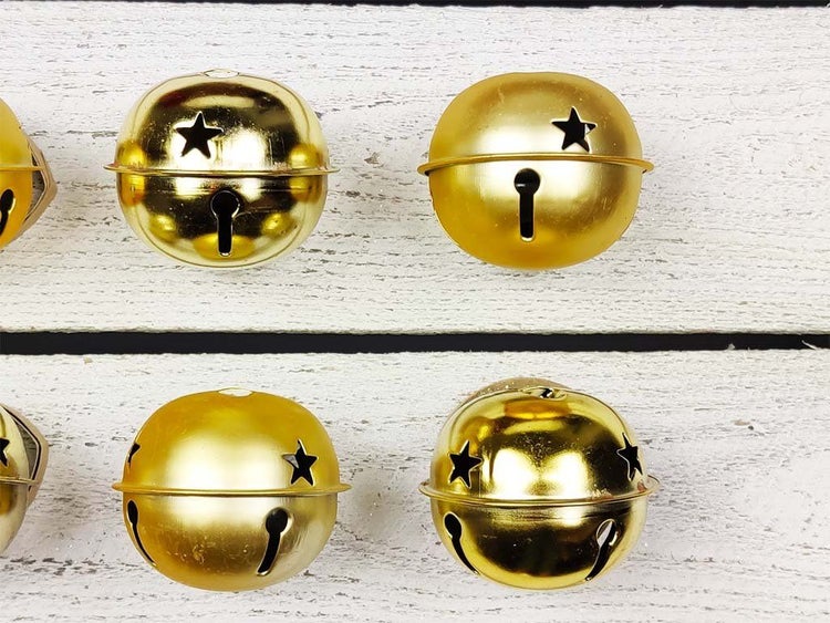 Mehrere metallene Dekoglöckchen mit Sternausstanzungen für weihnachtliche Dekorationen.