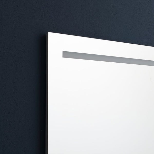 Detailansicht der Ecke eines Badezimmerspiegels mit integriertem Leuchtstreifen.