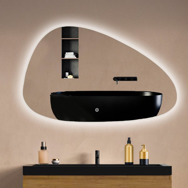 Organisch geformter Badezimmerspiegel mit LED Beleuchtung und Touch Schalter über einem Waschbecken mit Holzunterschrank.