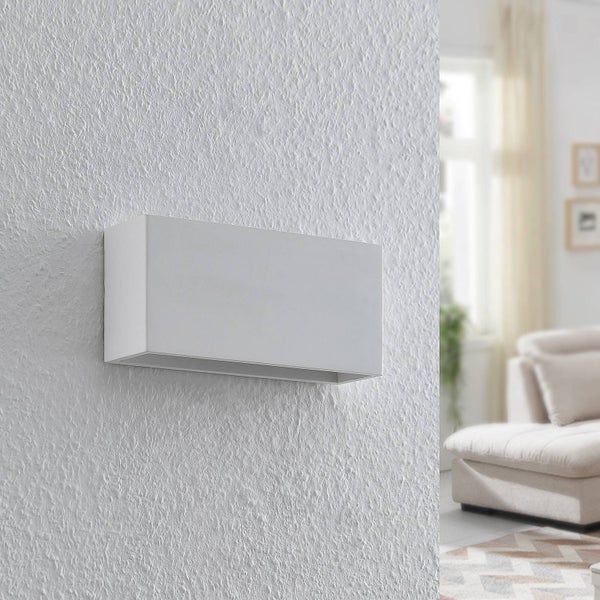 Weiße rechteckige Wandleuchte an einer strukturierten Wand in einem hellen Wohnzimmer.