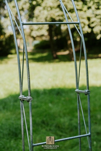 Detailansicht eines Metall-Rosenbogens im Garten