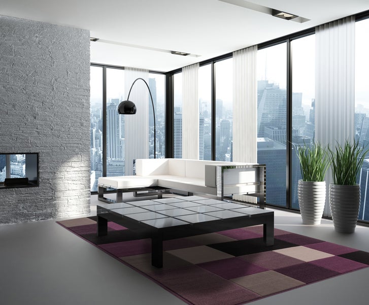 Modernes Wohnzimmer mit Stadtblick, Ledersofa, quadratischem Couchtisch, Kamin an einer Ziegelwand und zwei großen Pflanzen in Töpfen.