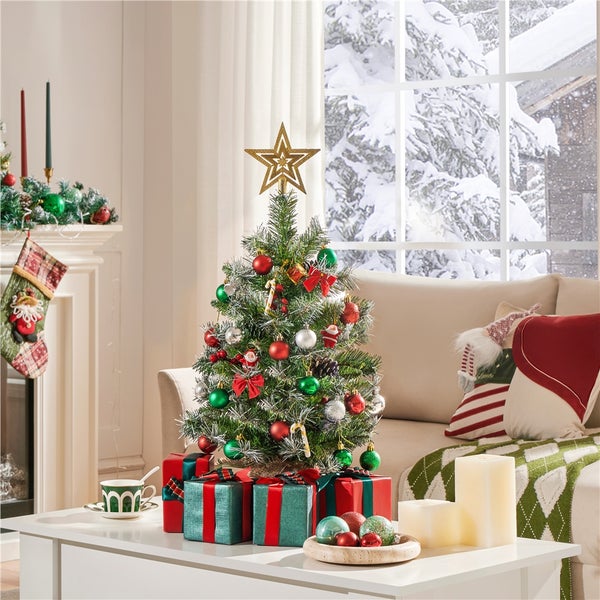 Dekorierter Weihnachtsbaum mit Geschenken im Wohnzimmer vor einem Fenster mit Schnee