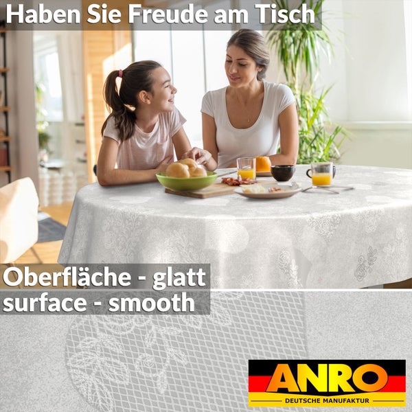 Runde Tischdecke mit glatter Oberfläche und floralem Spitzenmuster, Szene mit Familie am Tisch, ANRO Deutsche Manufaktur Logo.