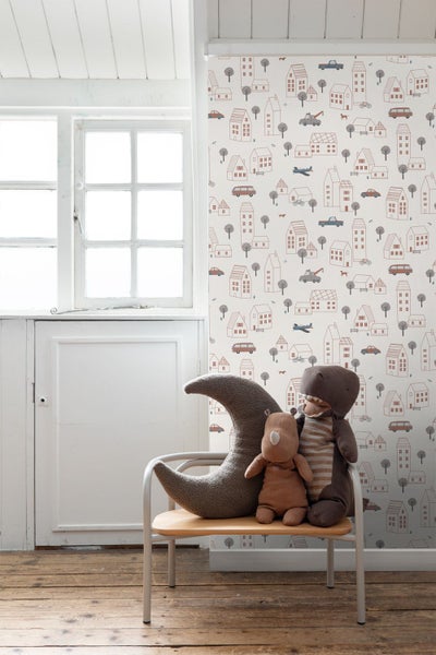 Kinderzimmer mit Tapete mit Häuser-, Auto- und Flugzeugmuster, dekoriert mit Stofftieren