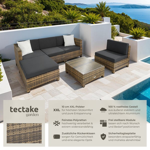 Gartenlounge-Set aus Polyrattan mit Tisch und grauen Auflagen auf einer Terrasse mit Meerblick