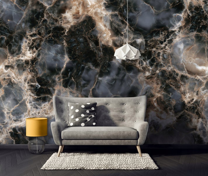 Wohnzimmer mit Vliestapete in Marmoroptik und modernem Sofa, Stehlampe sowie Pendelleuchte vor einer dunklen Wand gestaltet.