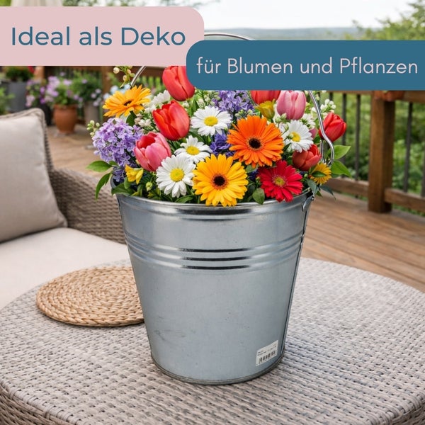 Dekorative Zinkwanne gefüllt mit Blumen auf einem Gartentisch.