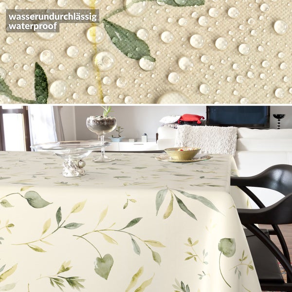Wasserundurchlässige Tischdecke mit Blättermuster auf einem Tisch in einem Wohnzimmer. Nahaufnahme zeigt Wassertropfen auf dem Stoff.