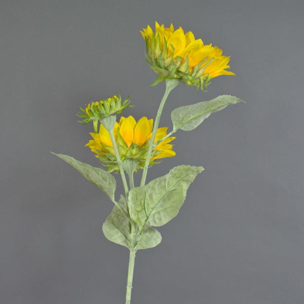 Künstliche Sonnenblume mit zwei gelben Blüten und einer Knospe an einem grünen Stiel mit Blättern.