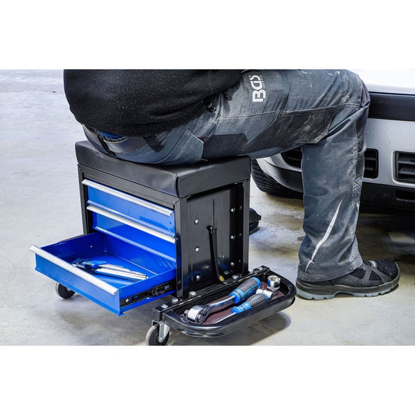Mobiler Werkstatt-Rollhocker mit Polstersitz, drei blauen Schubladen und Werkzeugablage, im Einsatz an einem Fahrzeug.