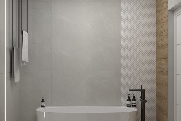 Modernes Badezimmer mit grauen Fliesen, Badewanne und Handtuchwärmer