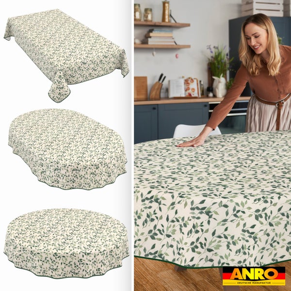 Abwaschbare Tischdecke mit grünem Blättermuster in rechteckiger, ovaler und runder Form. Frau deckt Tisch in heller, moderner Küche. Anro Logo.