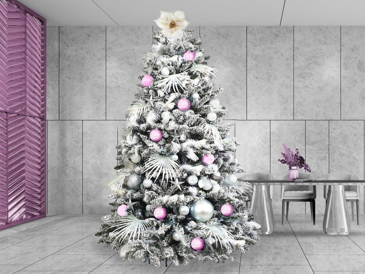Künstlicher Weihnachtsbaum mit Schnee, geschmückt mit Kugeln und dekorativen Elementen in einem modernen Wohnraum.