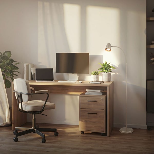 Ein moderner Schreibtisch mit Holzoptik, Rollcontainer, Laptop, Monitor und Schreibtischstuhl in einem organisierten, lichtdurchfluteten Arbeitszimmer