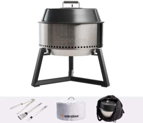 Solo Stove Holzkohlegrill aus Edelstahl mit Deckel, Untergestell und Zubehör wie Grillbesteck, Abdeckhaube und Tragetasche.