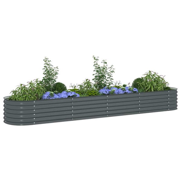 Langes, ovales Hochbeet aus anthrazitfarbenem Wellstahl, bepflanzt mit verschiedenen grünen Pflanzen und blauen Blumen.