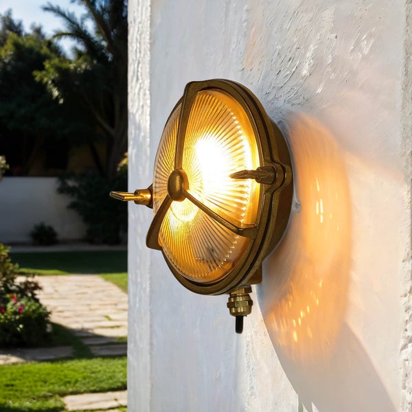 Runde Messing-Außenleuchte an einer Wand montiert