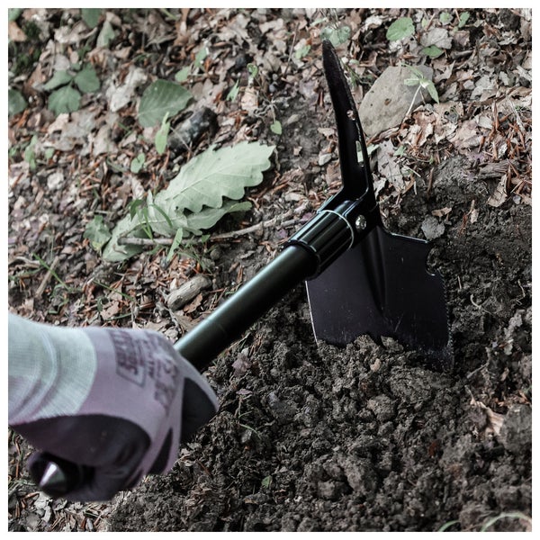 Person gräbt mit einer Klappspaten im Garten.